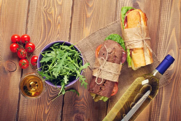 Twee broodjes, salade en witte wijn — Stockfoto