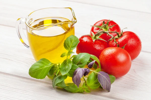 Olio d'oliva, pomodori, basilico sul tavolo di legno — Foto Stock