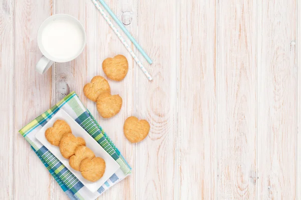 Cup of milk and heart shaped cookies — Stock Photo, Image