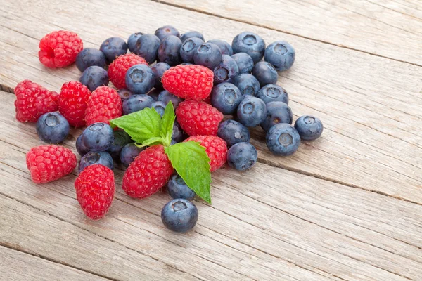 Blaubeeren und Himbeeren mit Minzblättern — Stockfoto