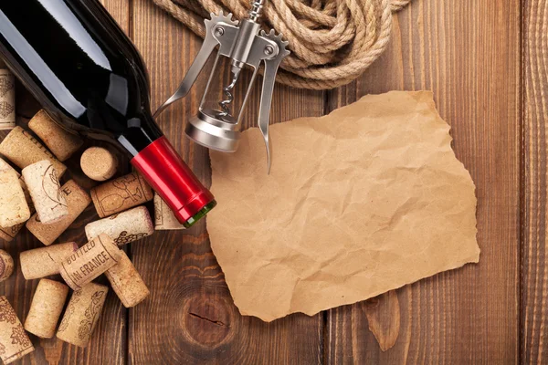 Red wine bottle, corks and corkscrew — Stock Photo, Image