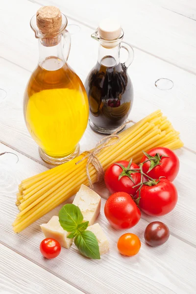Pastas, tomates, albahaca sobre mesa de madera — Foto de Stock
