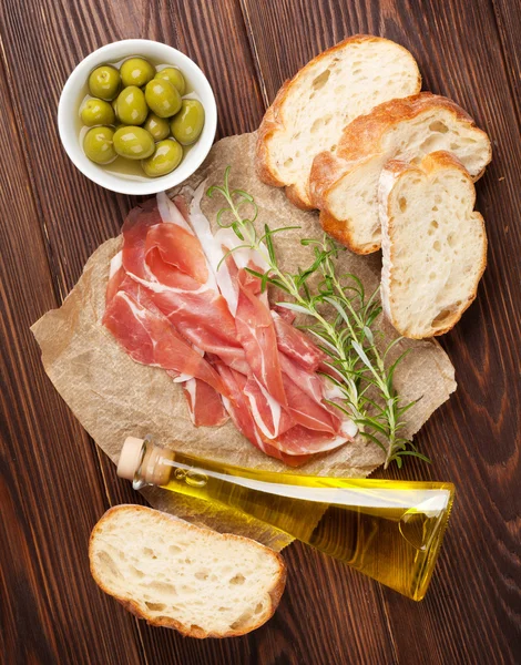 Prosciutto, olives and olive oil — Stock Photo, Image