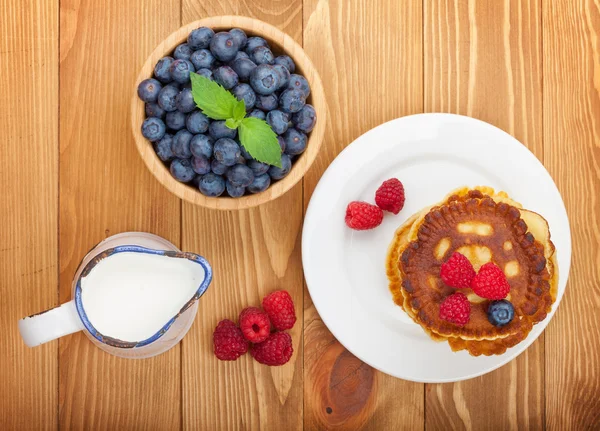 Pannenkoeken met frambozen, bosbessen en melk — Stockfoto