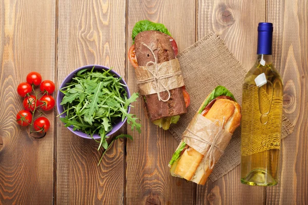 Два сэндвича, салат и белое вино — стоковое фото