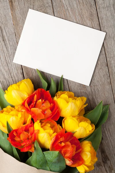 Ramo de tulipanes y tarjeta de felicitación en blanco — Foto de Stock