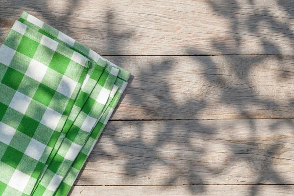 Empty wooden garden table with tablecloth