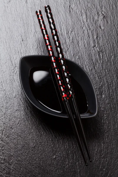 Japanese sushi chopsticks over sauce bowl — Stock Photo, Image