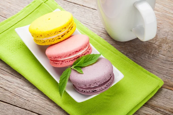 Colorful macaron cookies and cup of milk — Stock Photo, Image