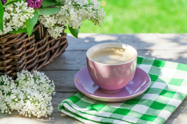 Coffee cup and colorful lilac flowers — Stock Photo, Image