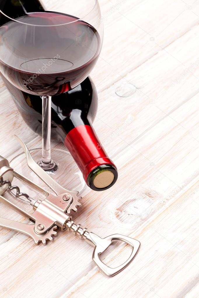 Red wine bottle, glass and corkscrew