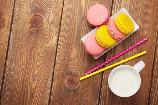 Colorful macaron cookies and cup of milk — Stock Photo, Image