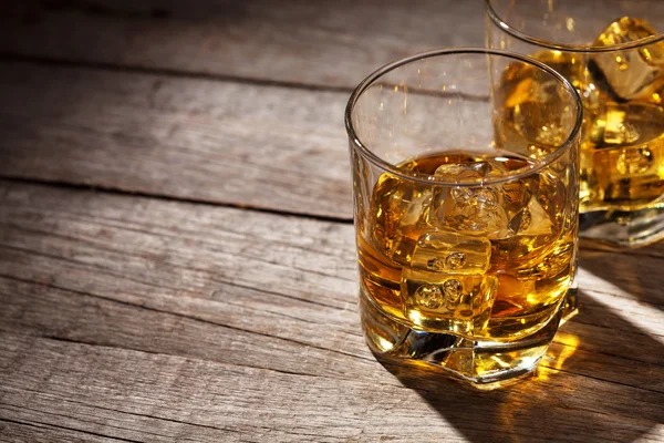 Glas whiskey med is på trä — Stockfoto