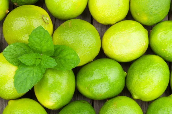 Frische reife Limetten mit Minze — Stockfoto