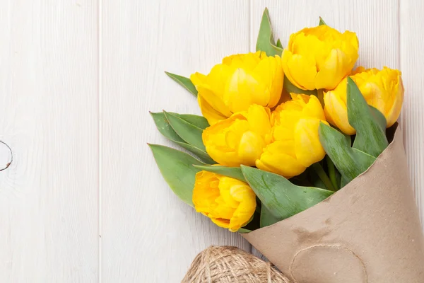 Yellow tulips over wooden table — Stock Photo, Image