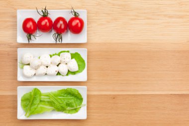 Tomatoes, mozzarella and salad leaves clipart