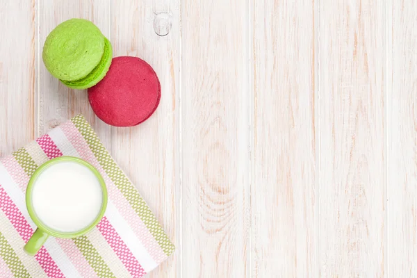 Colorful macarons and cup of milk