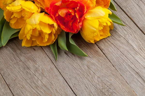 Colorful tulips over wooden table — Stock Photo, Image