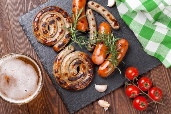 Tazza di birra e salsicce alla griglia — Foto Stock