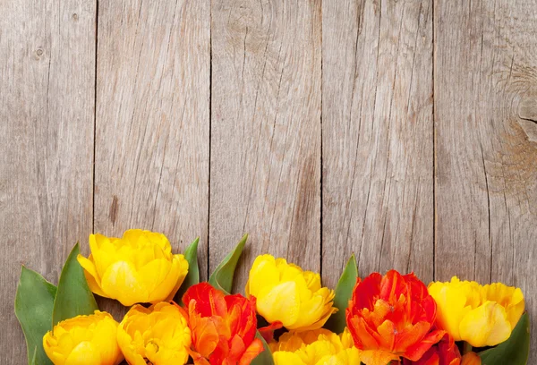 Tulipanes coloridos en mesa de madera —  Fotos de Stock