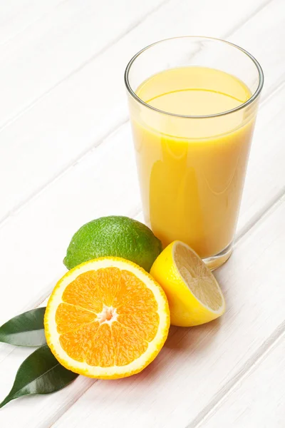 Frutas cítricas e copo de suco . — Fotografia de Stock