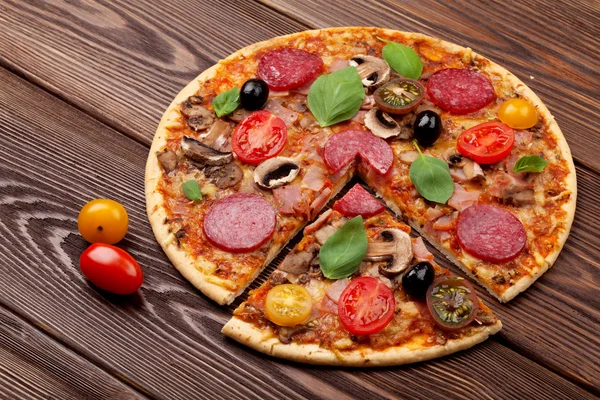 Pizza med pepperoni, tomater, oliver och basilika — Stockfoto