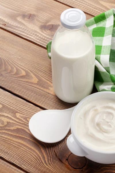 Crema agria en un tazón y botella de leche —  Fotos de Stock