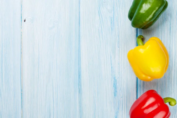 Colorful bell peppers on wooden table — Stock Photo, Image