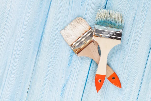 Paintbrush over blue wood — Stok fotoğraf