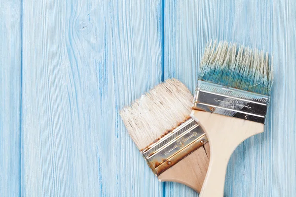 Paintbrush over blue wood — Stockfoto