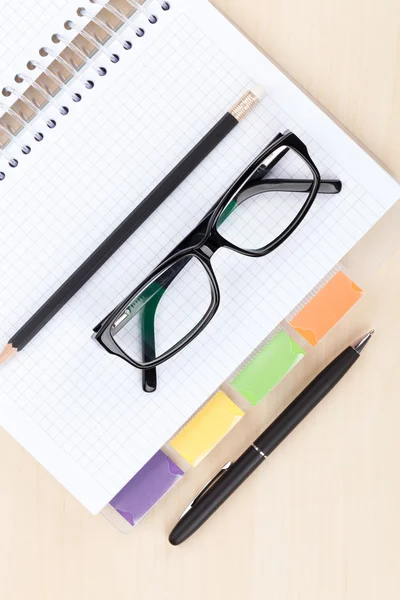 Tisch mit Brille, Notizblock und Bleistift — Stockfoto