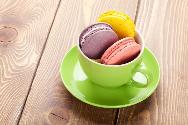 Biscoitos macaron coloridos em xícara de café — Fotografia de Stock