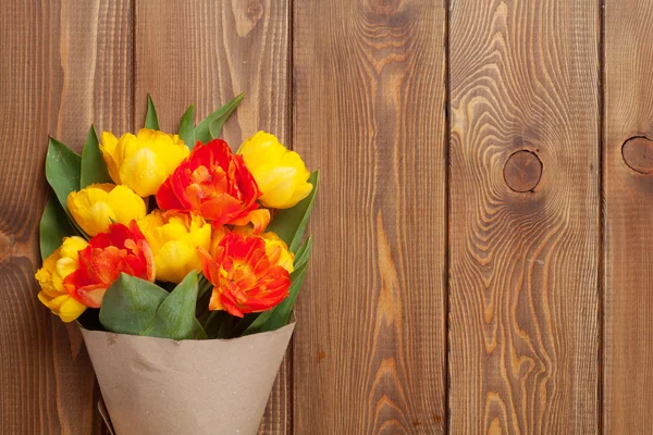 Barevné tulipány dřevěný stůl — Stock fotografie