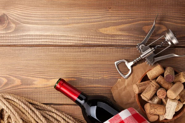 Red wine bottle, corks and corkscrew — Stock Photo, Image