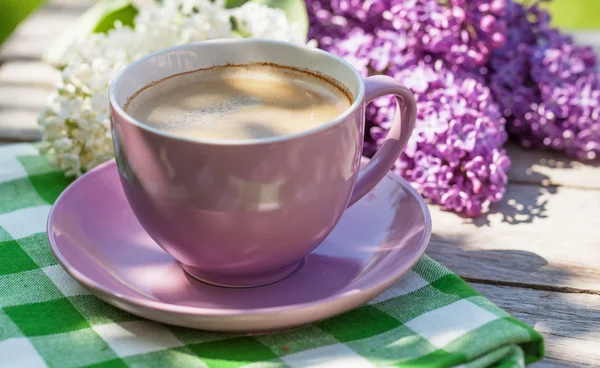 Coffee cup and colorful lilac flowers — Stock Photo, Image