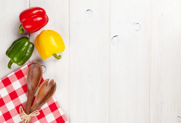 Colorful bell peppers and kitchen utensils — Stock Photo, Image