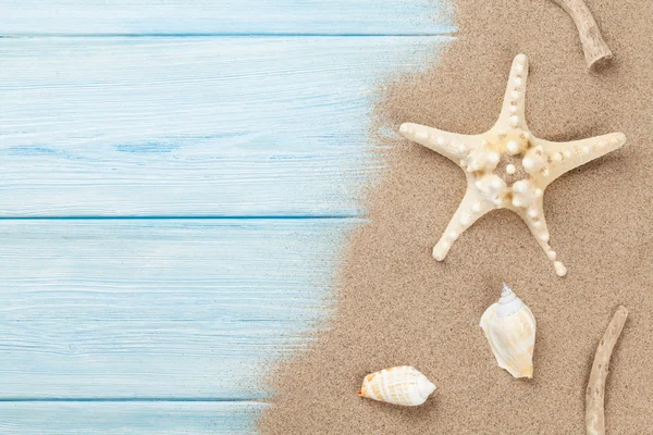 Arena marina con estrellas de mar y conchas sobre madera — Foto de Stock