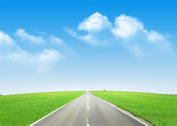 road through the green field and sky