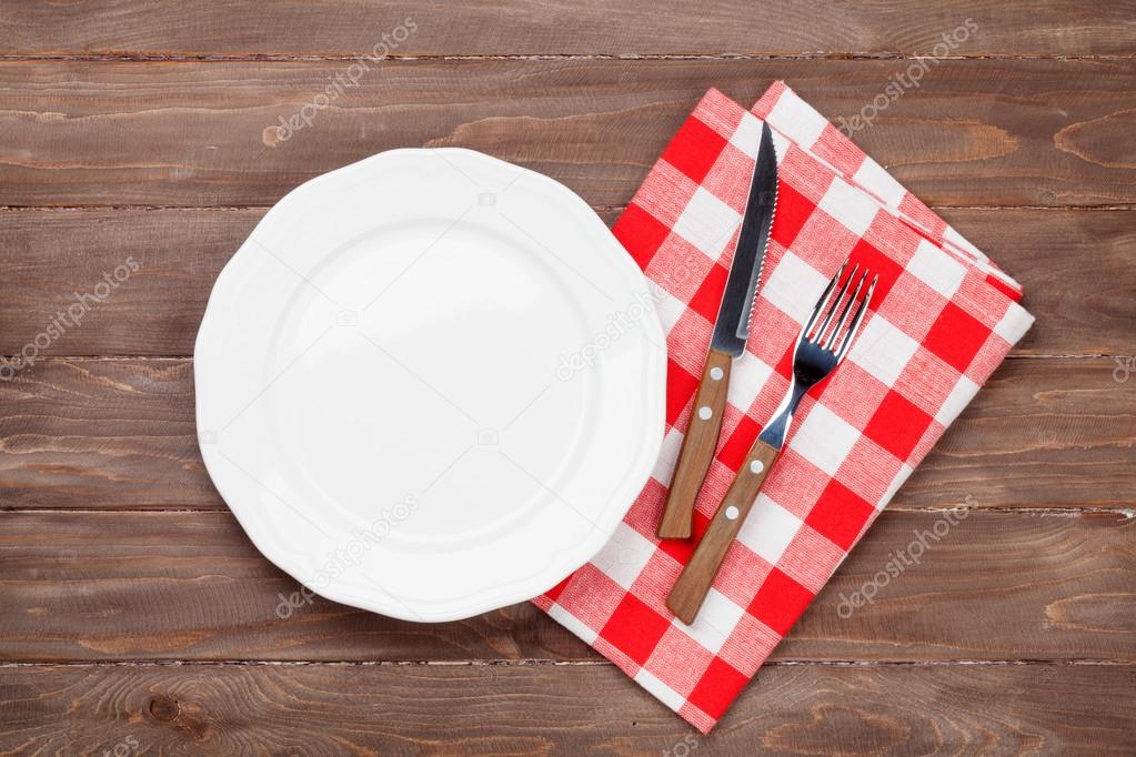 Empty plate and silverware over table