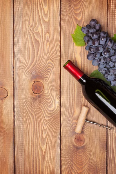 Wine bottle and bunch of red grapes — Stock Photo, Image