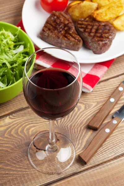 Bicchiere di vino rosso e bistecca con insalata — Foto Stock