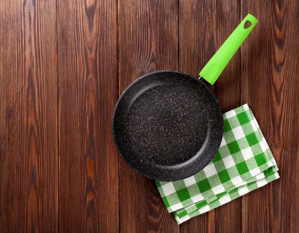 Frying pan on wooden table — Stock Photo, Image