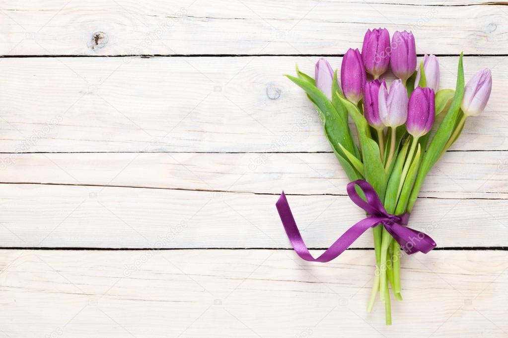 Purple tulips over wooden table