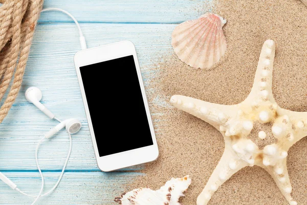 Deniz deniz yıldızı ile kum üstünde Smartphone — Stok fotoğraf