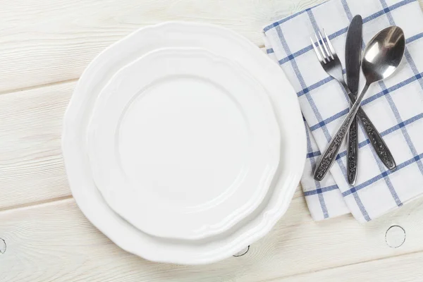 Empty plate and silverware over table — Stock Photo, Image