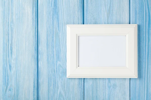 Photo frame on blue wooden wall — Stock Photo, Image