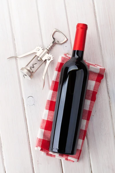 Красная бутылка вина и штопор — стоковое фото