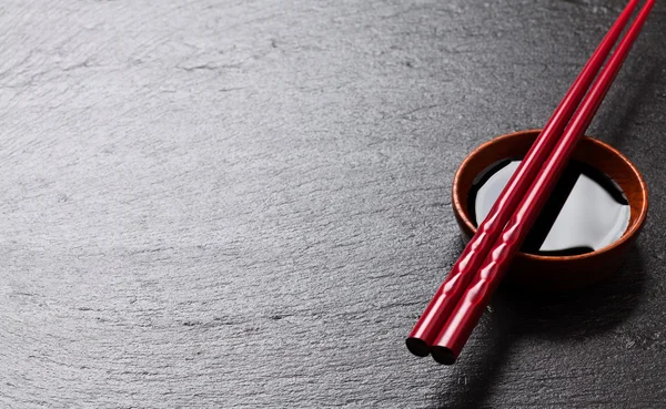 Japanese sushi chopsticks over soy sauce — Stock Photo, Image