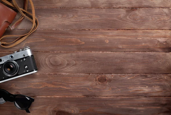 Kamera ve ahşap masa üzerinde güneş gözlüğü