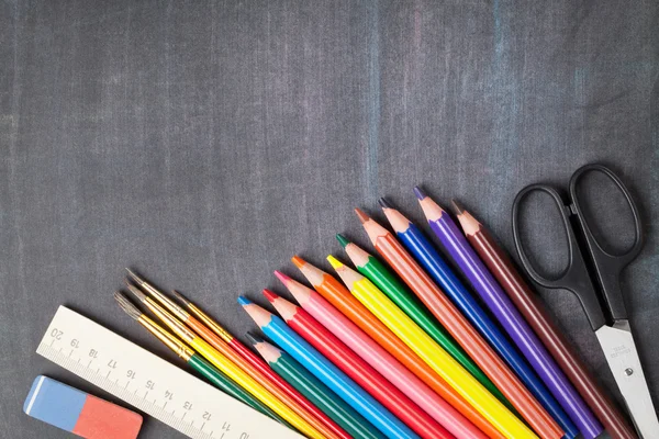 School supplies on blackboard — Stock Photo, Image